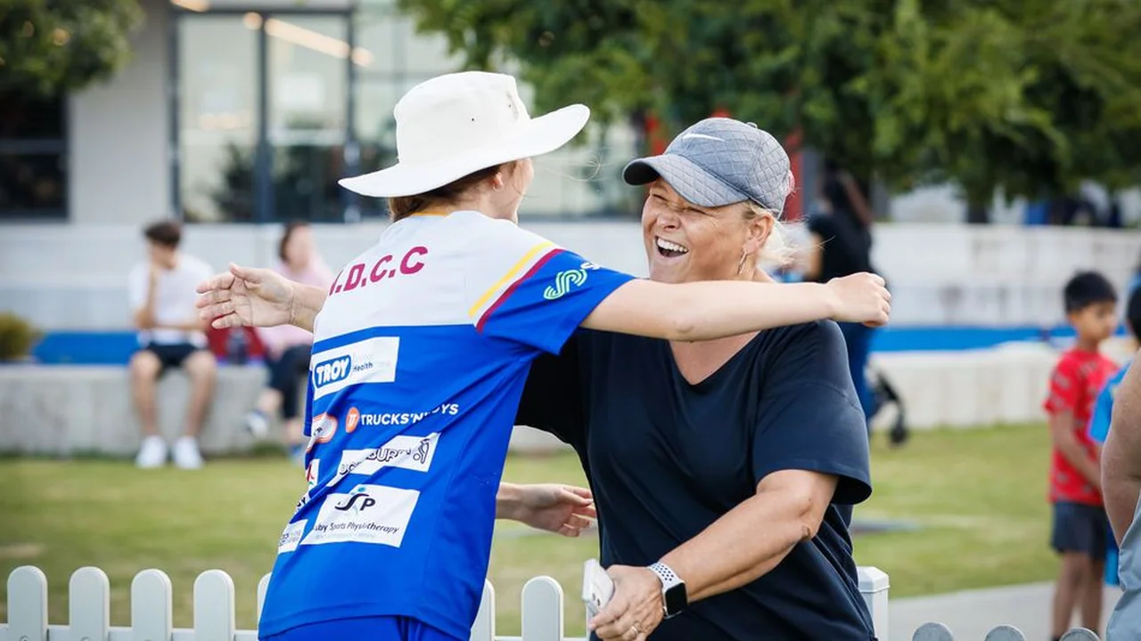Two women embrace at a cricket ground as the South Australian Cricket Association (SACA) launches its Women in Cricket Network.